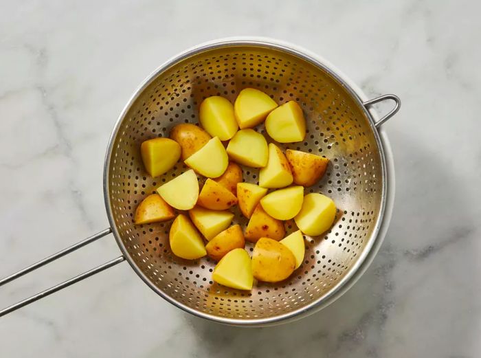 Potatoes draining in a colander.