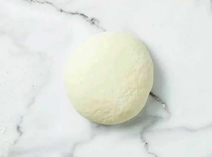 The dough after it’s been kneaded on a floured surface.
