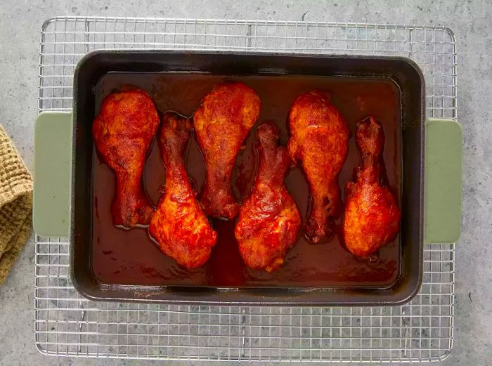 Five drumsticks fully cooked and resting in the baking dish