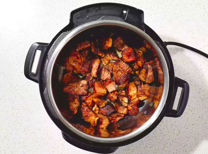 Chunks of meat cooking in the pressure cooker