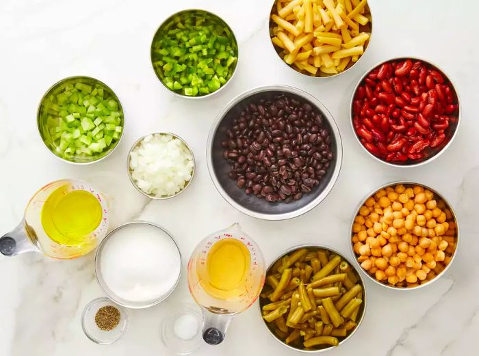 In a large bowl, combine chickpeas, kidney beans, black beans, green beans, wax beans, green bell pepper, onion, and celery.