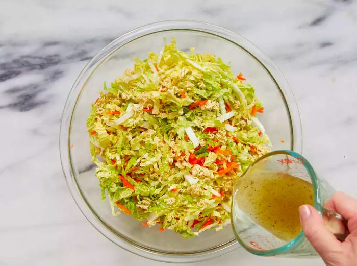 Dressing being poured over the salad mixture.