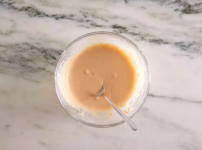 Aerial view of French fry batter resting in a glass bowl.