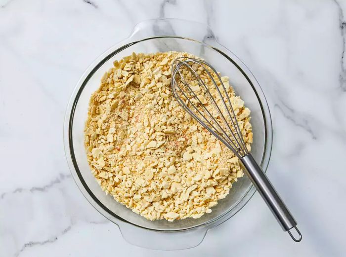 A mixture of crushed crackers, garlic powder, and seasoned salt in a bowl