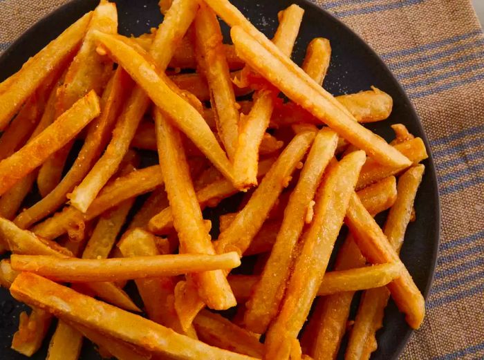 A top-down view of a large bowl filled with crispy, golden brown French fries.