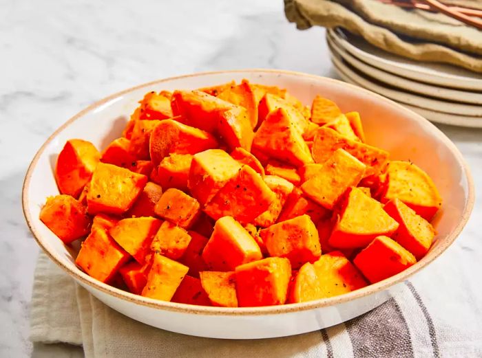 A high-angle view of a bowl filled with baked sweet potatoes.