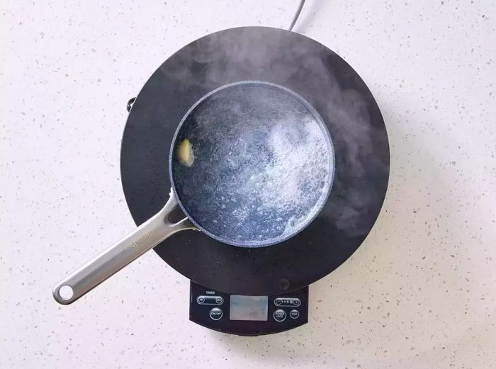 A pot boiling with vinegar, water, salt, and garlic