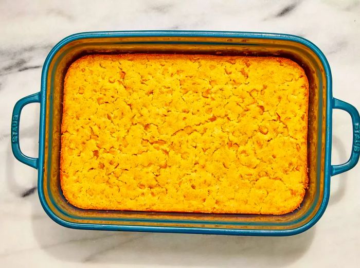 A casserole dish with a golden cornbread topping, fresh out of the oven