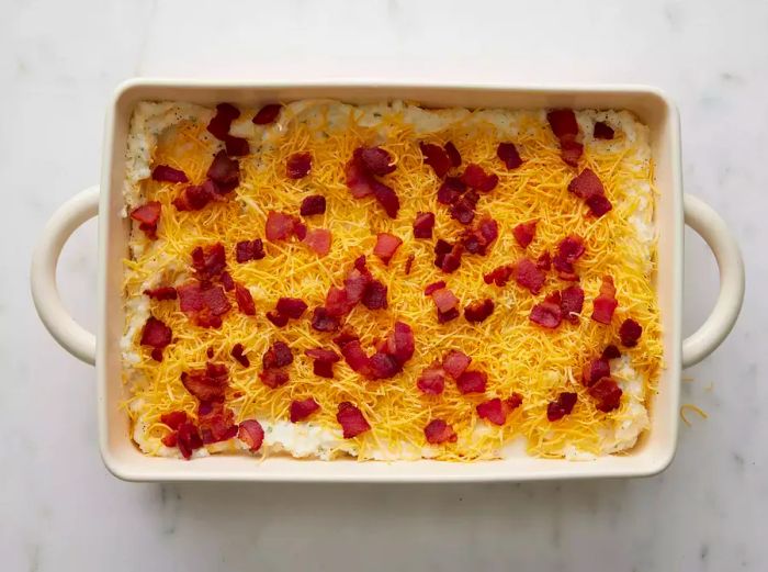 An overhead view of the twice-baked potato casserole in the dish, ready to be baked.