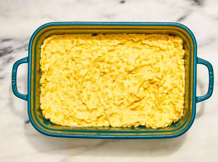 A casserole dish filled with cornbread batter ready to bake