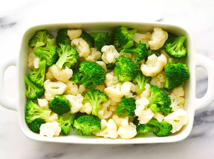 A top-down view of broccoli and cauliflower in a casserole dish