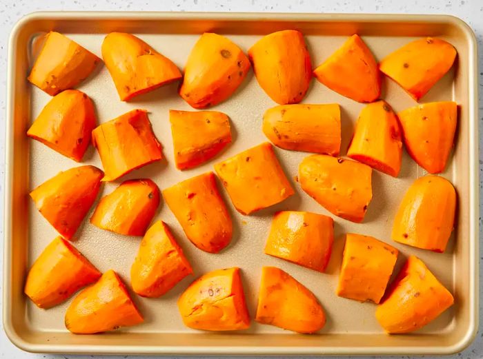 Potatoes arranged on a baking sheet, ready for the next step.