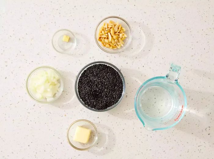 Black rice ingredients arranged in glass bowls on the kitchen counter