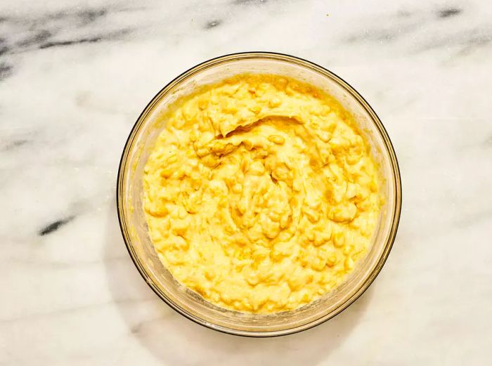 A large mixing bowl filled with cornbread casserole batter