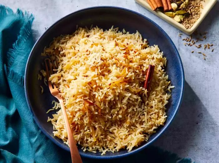 A bowl of Indian-style basmati rice accompanied by a small dish of spices