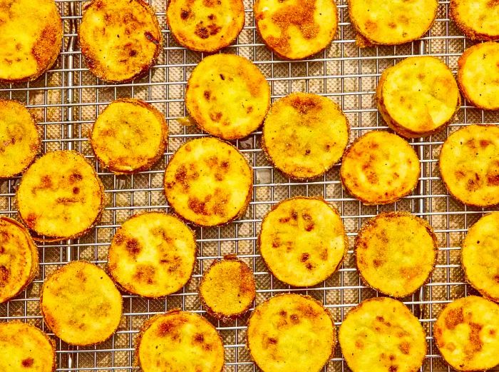 A wire rack holding freshly fried country squash slices.