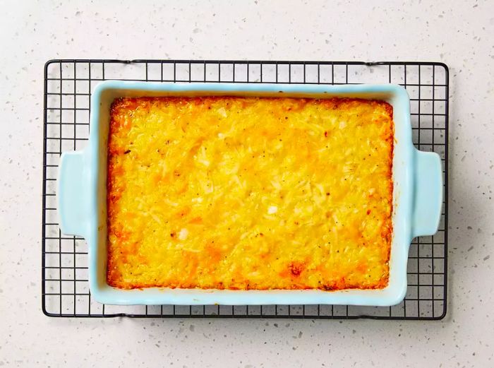 A freshly baked restaurant-style hashbrown casserole cooling on a wire rack.