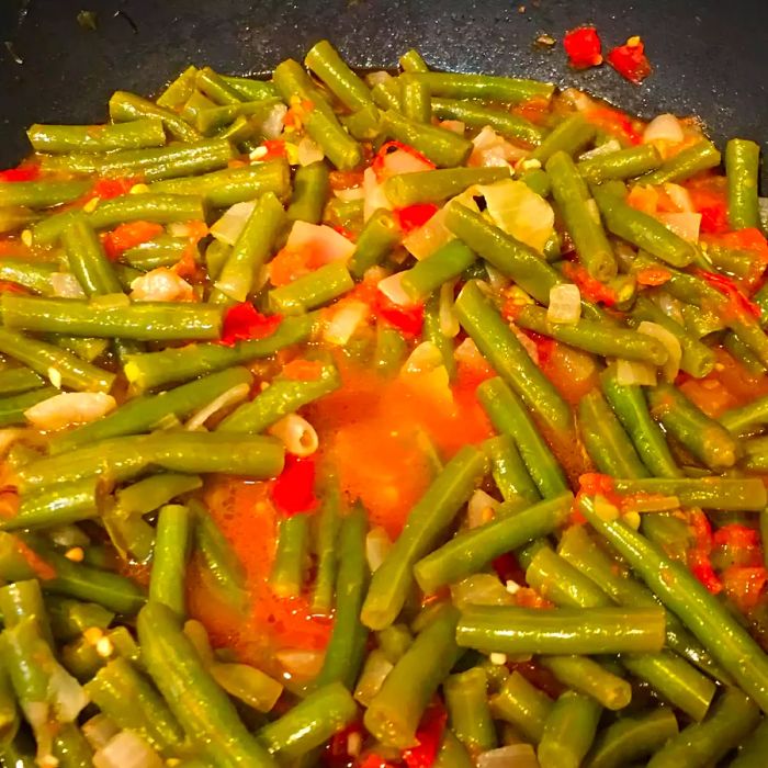 Close-up shot of Greek Green Beans cooking in a pan.