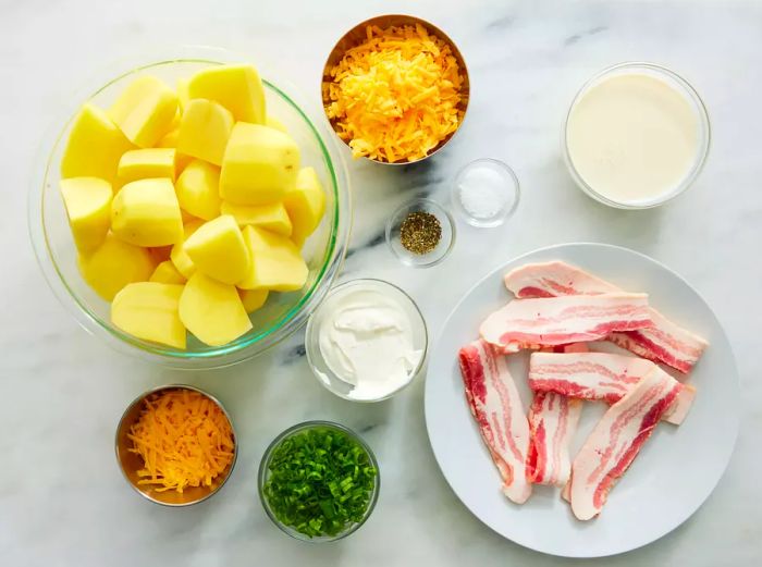 Ingredients for Loaded Baked Potato Casserole arranged on a marble countertop