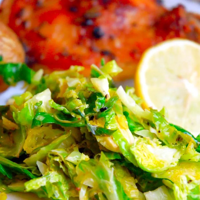 Close-up of Brussels sprouts served with lemon and chicken on a plate