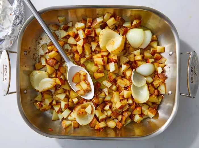 Roasted Potatoes and Onions served in a baking dish with a spoon