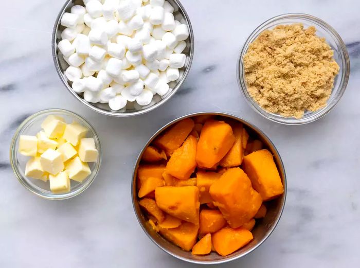 Aerial view of the ingredients for candied yams arranged in various bowls.