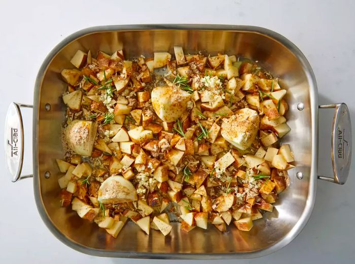 Potatoes and onions with rosemary in a metal baking dish