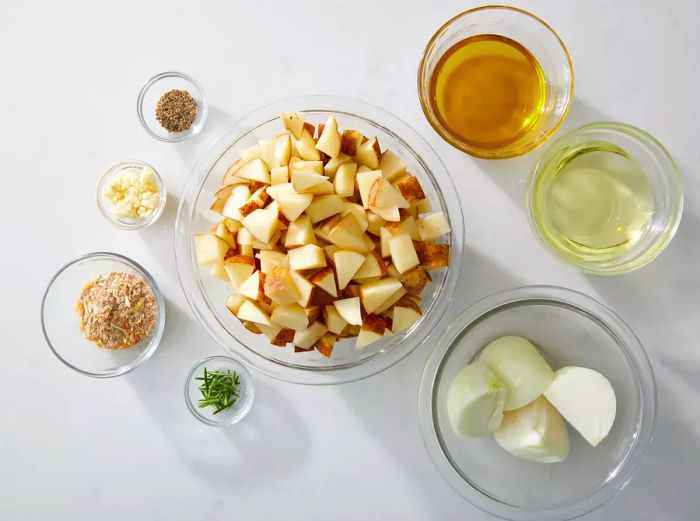 Ingredients for Roasted Potatoes and Onions displayed in glass bowls