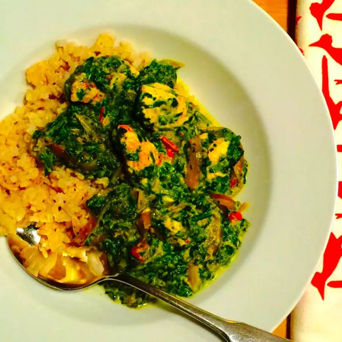 A bowl of Authentic Saag Paneer with a spoon resting inside.