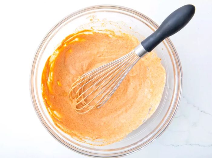 An overhead shot of Tikka Masala sauces being blended together in a bowl.