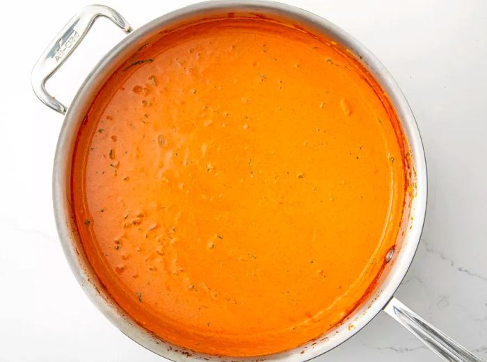 An overhead view of Tikka Masala sauce simmering in a saucepan.