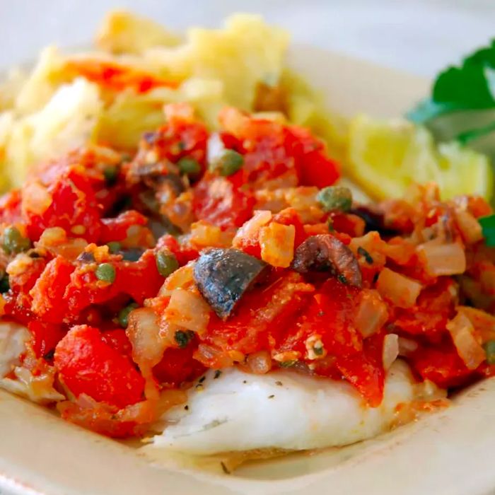 Flounder fillets topped with a savory mix of tomatoes, capers, onions, garlic, and olives