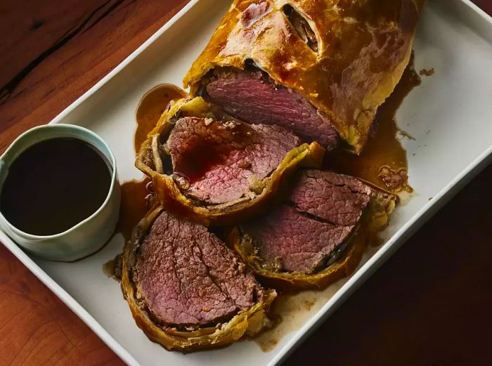 A whole Beef Wellington with a few slices cut into it