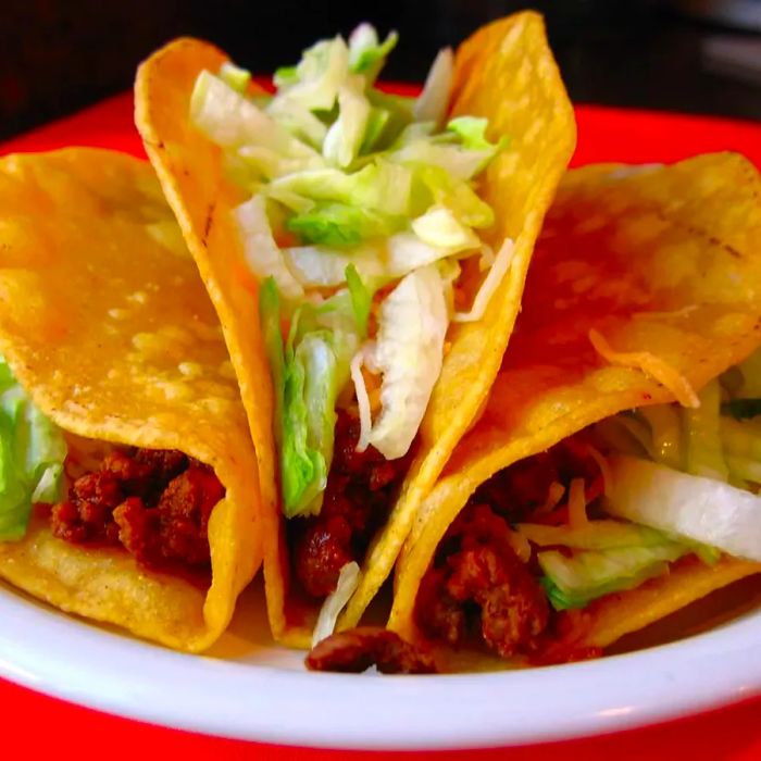 three golden crispy tacos on a plate