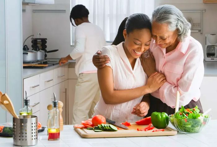 A grandmother and granddaughter preparing food together at the kitchen counter