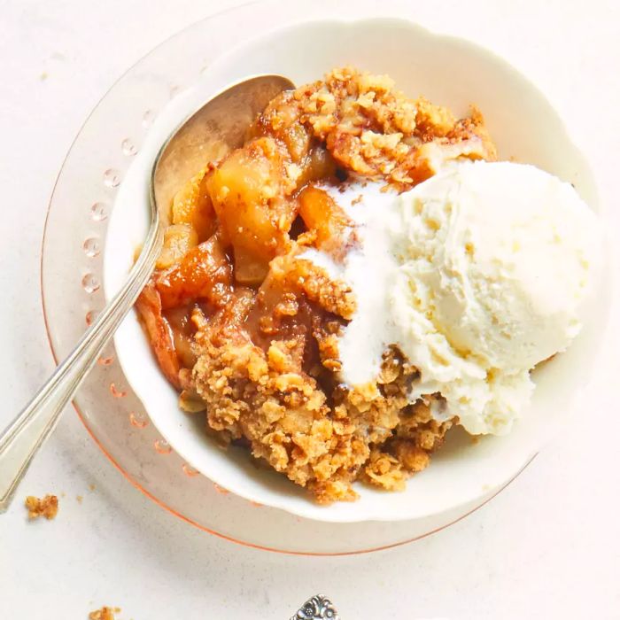 A warm apple crisp served with a scoop of vanilla ice cream