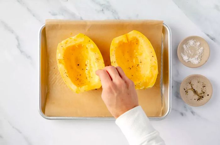 Seasoning the cut sides of spaghetti squash halves