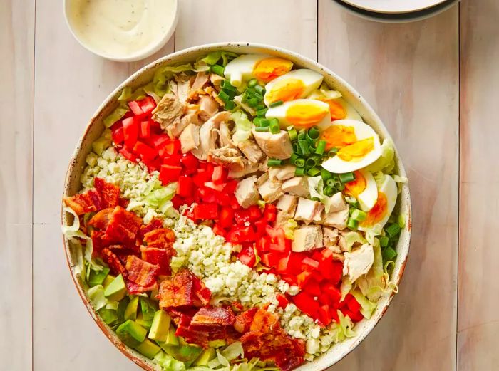 An overhead shot of a large bowl filled with Cobb salad.