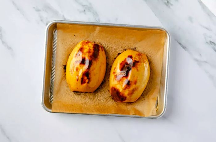 Spaghetti squash halves on a baking sheet after roasting