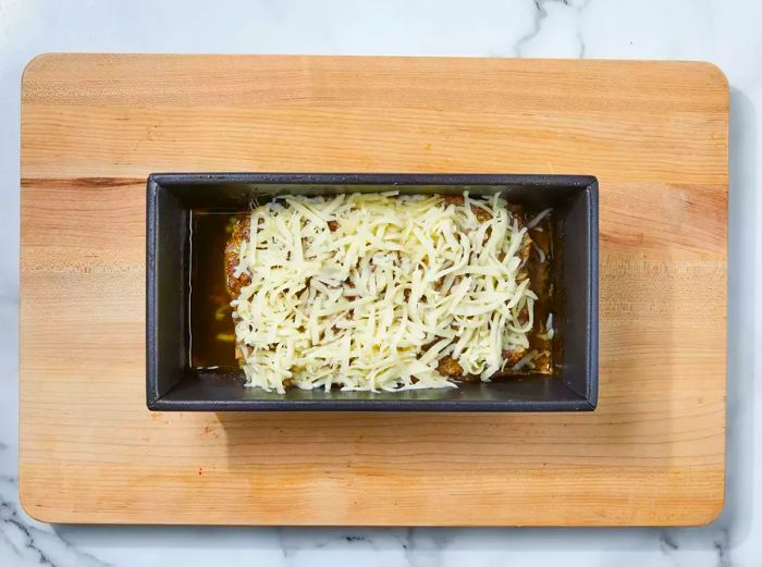 Meatloaf topped with melted cheese and allowed to rest until the cheese is fully melted.