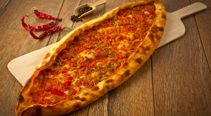 Pide is a flatbread made by stretching dough and filling it with various ingredients, creating a deliciously customizable meal.