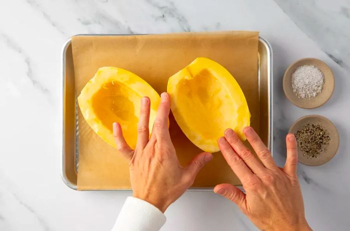 Rubbing oil into the cut sides of spaghetti squash halves before roasting