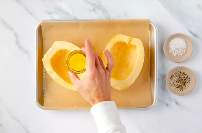 Drizzling oil over spaghetti squash for roasting