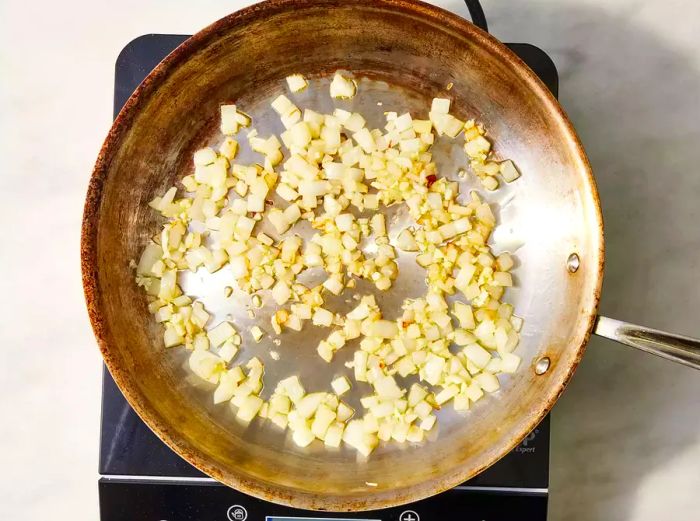 Onions and garlic sautéing in a pan on the stovetop