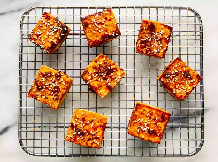 Baked tofu resting on a wire cooling rack