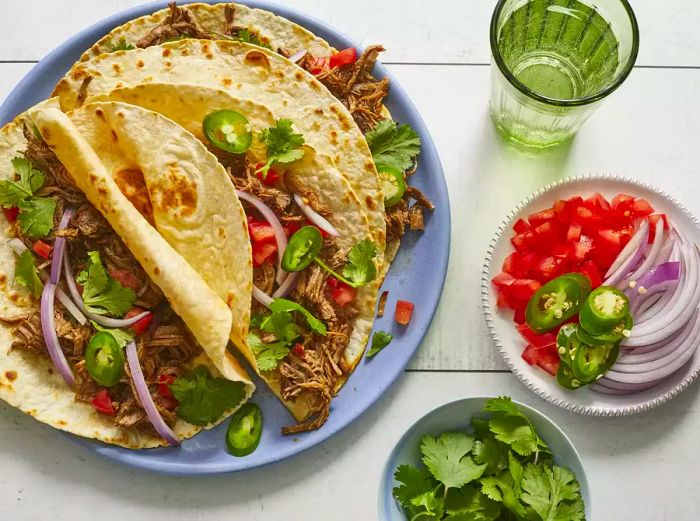 A top-down view of several barbacoa-style shredded beef tacos