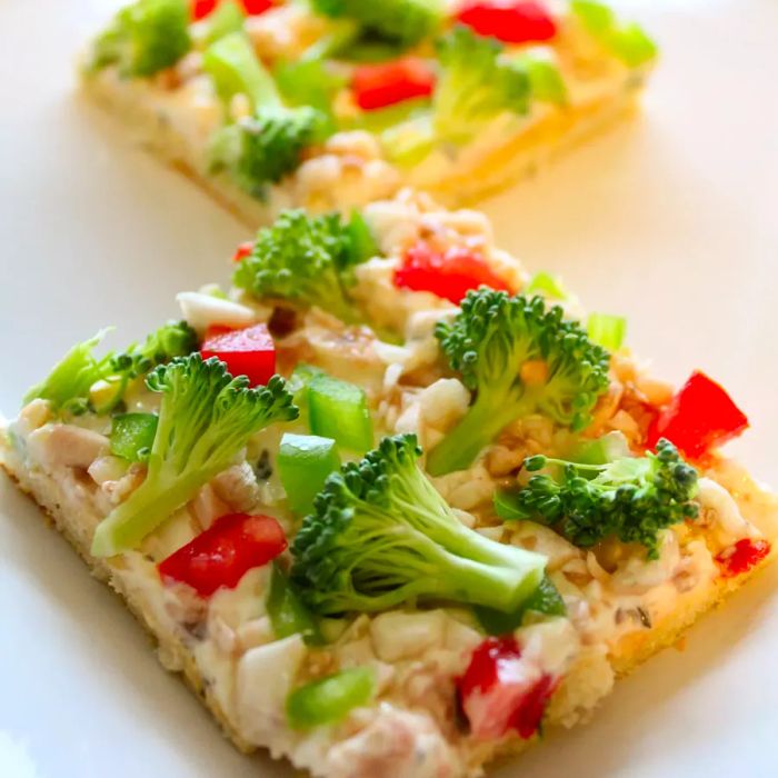 Close-up of Garden Veggie Pizza Squares with broccoli and red pepper on a white plate.