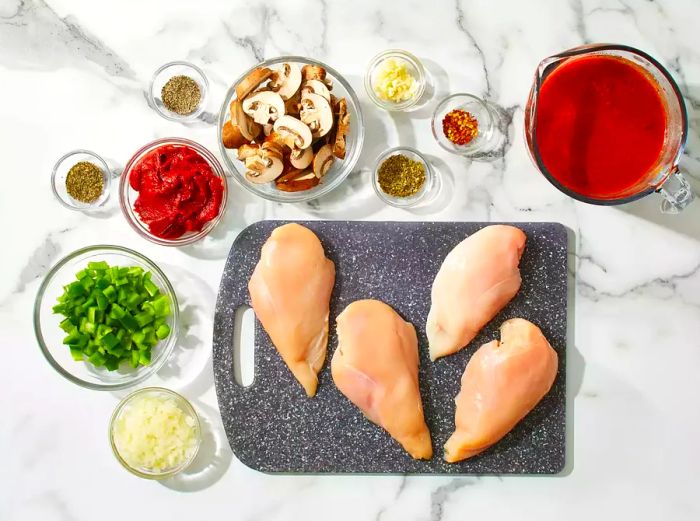 All ingredients are prepared for the chicken cacciatore in the slow cooker.