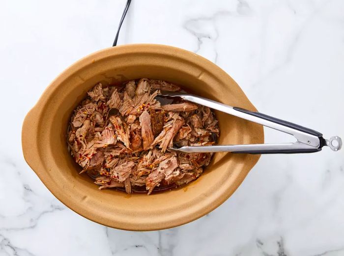 Sauce poured over the pork in the slow cooker, left on Low until serving time.