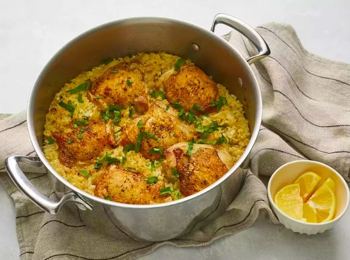 A bird's-eye view of a large pot filled with crispy chicken and rice